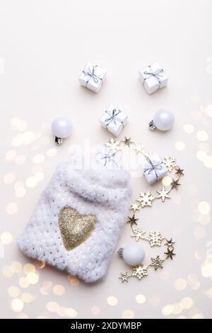 White fluffy sack with small gift boxes on beige background Stock Photo