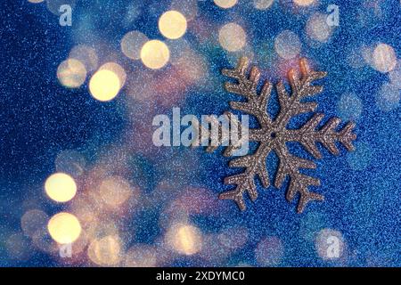 Golden snow flake on blue glitter background Stock Photo