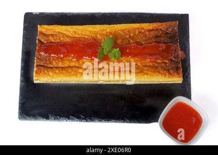 Cheesecake with strawberry jam on black board Stock Photo