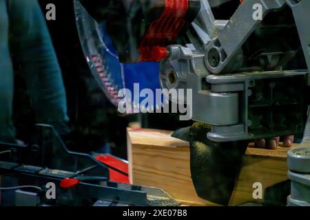 A worker cuts a wooden block using a circular saw Stock Photo