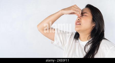 A woman with a runny nose. Asian woman suffering from stuffy nose having runny nose and bad breath caused by sinus infection. Stock Photo
