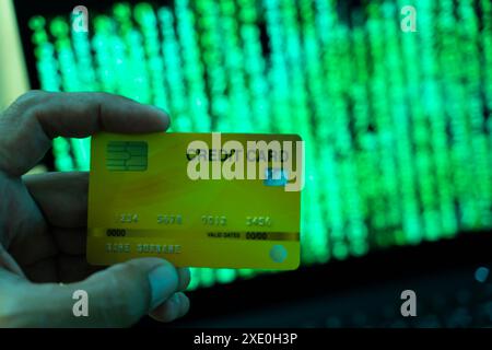 Internet crime concept. Hacker working on a code and stealing credit card with digital interface around. Cybersecurity, credit card. Stock Photo