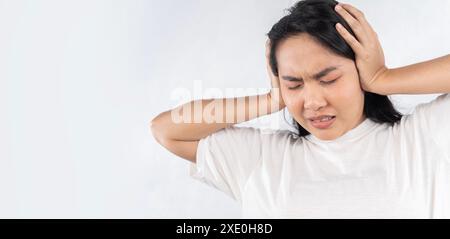 Tinnitus concept. Closeup side profile sick young woman having ear pain touching her painful head isolated on white background. Stock Photo