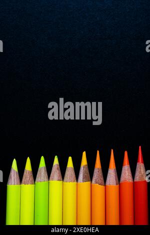 Pencils on black canvas yellow to red Stock Photo
