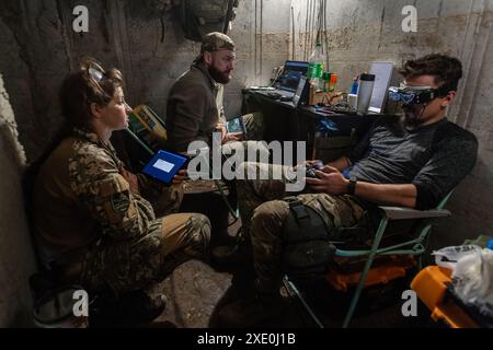 An FPV drone unit from the 92nd Brigade, known as 'Achilles', operates inside a bunker about 10 kilometers from the Russian border in Kharkiv Oblast, Ukraine. First Person View (FPV) drones have changed the nature of warfare in Ukraine, with both Ukrainian and Russian forces coming to rely on these drones, which are armed with explosives and remotely controlled by a pilot wearing a headset. (Photo by Laurel Chor / SOPA Images/Sipa USA) Stock Photo