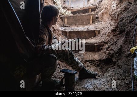 A female platoon commander (codename 'Shylka') eats inside the bunker used by a Ukrainian FPV drone unit from the 92nd Brigade, known as 'Achilles', about 10 kilometres from the Russian border in Kharkiv Oblast, Ukraine. First Person View (FPV) drones have changed the nature of warfare in Ukraine, with both Ukrainian and Russian forces coming to rely on these drones, which are armed with explosives and remotely controlled by a pilot wearing a headset. (Photo by Laurel Chor / SOPA Images/Sipa USA) Stock Photo