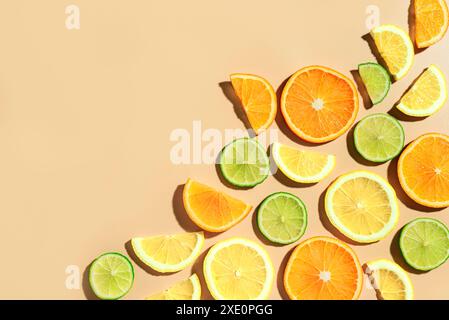 Creative background made of summer tropical citrus fruits, orange, tangerine, lemon, lime on pastel beige background, copy space. Trendy food concept Stock Photo