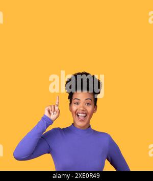 Woman With Curly Hair Pointing Up With Excitement Stock Photo