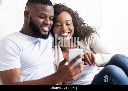 Couple Using Smartphone Together Indoors Stock Photo