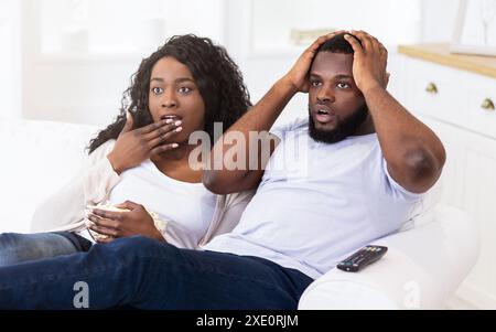 Shocked Couple Watching TV Stock Photo