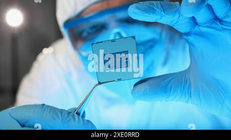 Scientist developer in protective suit holds microcircuit Stock Photo