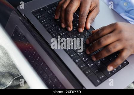 Close-up of a male dark-skinned hand working on a laptop, American African business, online chat, Stock Photo