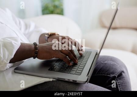 Close-up of a man's dark-skinned hand working on a laptop, American African business, working online, chat Stock Photo