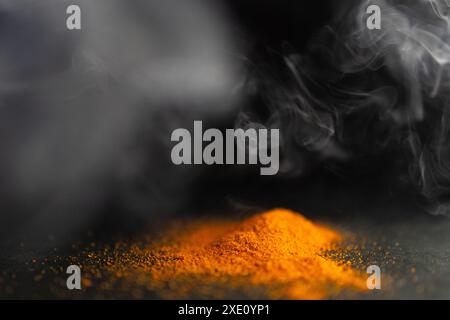 Horizontal picture of pile of red parika with smoke around it.Black background Stock Photo