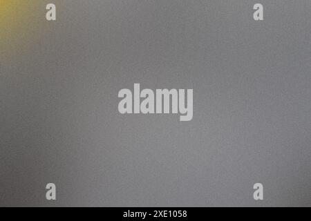 Image of a textured gray background with a subtle gradient and a soft yellow light fading in the upper left corner Stock Photo