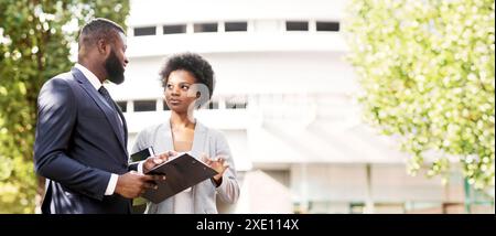 Couple of business partners checking work documentation outdoors Stock Photo