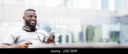 Man Using Smartphone and Drinking Coffee Outdoors Stock Photo