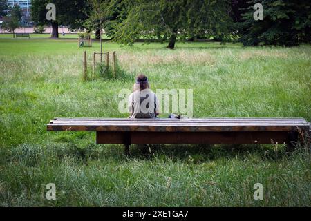 London, United Kingdom. 25th June, 2024. A person rest under the shadow of a tree during the hottest day in London so far. Temperatures hit 28.3C (82.9F).  Laura Gaggero / Alamy Live News Stock Photo