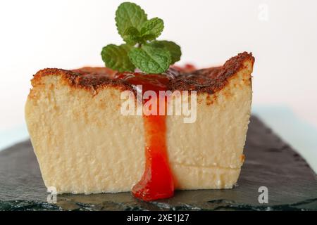Cheesecake with strawberry jam on black board Stock Photo