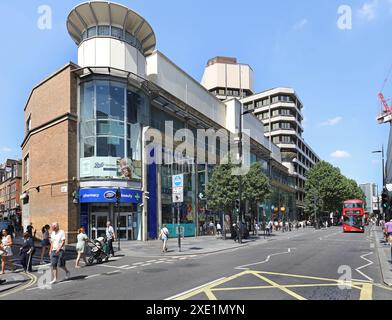 View North up Tottenham Court Road, London, UK. Shows shops and offices on the west side including Boots store, pedestrians and new Routemaster bus. Stock Photo