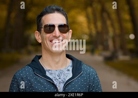 Smiling mediterranean man in casual sports clothing and sunglasses. Stock Photo
