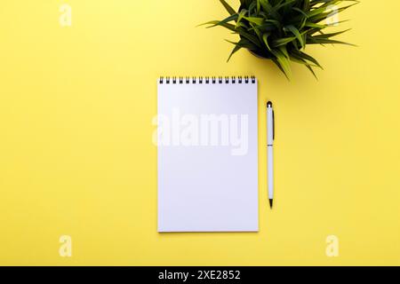 Empty notepad and pen on yellow trendy background, top view flat lay copy space Stock Photo