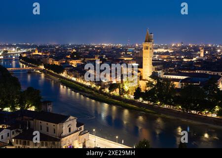 Verona, Italy - June 2022: panorama by night. Illuminated cityscape with scenic bridge. Stock Photo