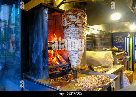 Grilled chicken meat on a vertical rotisserie used in traditional Stock Photo