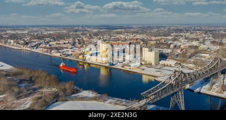 Panoramic aerial view of famous railway Rendsburg High Bridge with cargo ship with snow and frost in Stock Photo