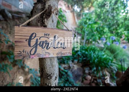 Garden welcome sign with mediterranean courtyard as background. English language letters Stock Photo