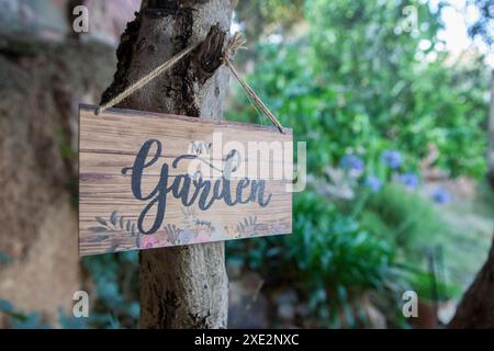 Garden sign with mediterranean courtyard as background. English language letters Stock Photo