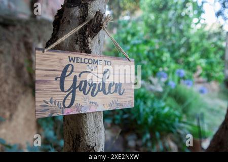 Garden welcome sign with mediterranean courtyard as background. English language letters Stock Photo