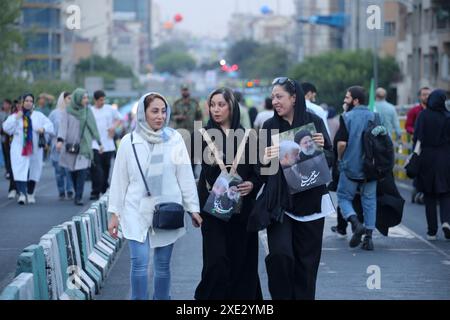 Tehran, Iran. 25th June, 2024. Iranian young women hold posters of Iranian late president Ebrahim Raisi and Iranian presidency candidate Said Jalili during a ceremony to mark the Shiite holiday of Eid al-Ghadir in Tehran. Eid al-Ghadir marks the crucial event when Muhammad declared Imam Ali his rightful successor in his final sermon at Ghadir Khumm. This proclamation holds immense significance in Islamic history and deserves our attention and reverence. (Credit Image: © Rouzbeh Fouladi/ZUMA Press Wire) EDITORIAL USAGE ONLY! Not for Commercial USAGE! Stock Photo