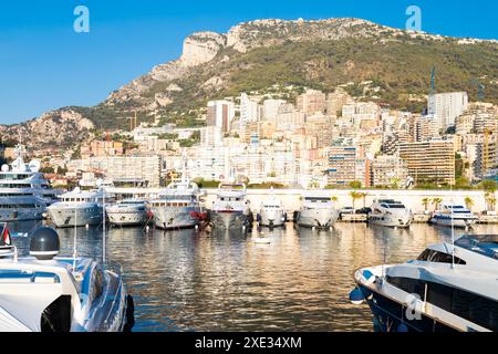 Monte Carlo, Monaco - Port Hercule with luxury yachts,  boats, and scenery skyline Stock Photo