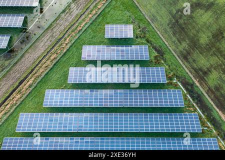 Field with several rows of solar panels, in the style of symmetrical compositions. Aerial view of so Stock Photo
