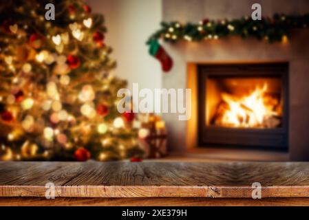 Wooden table with blurred Christmas tree and fireplace background. Stock Photo