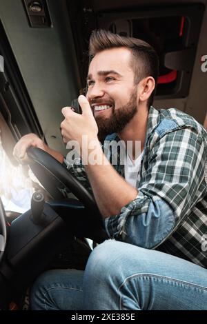 Truck driver talking by CB radio system in his vehicle Stock Photo