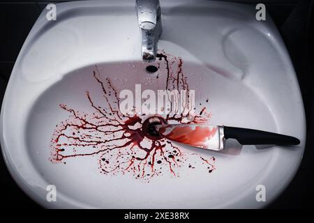 Dirty bathroom sink with blood splatter and knife Stock Photo