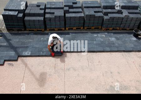 Construction of pavement and wooden pallets. Laying concrete paving slabs in house courtyard drivewa Stock Photo