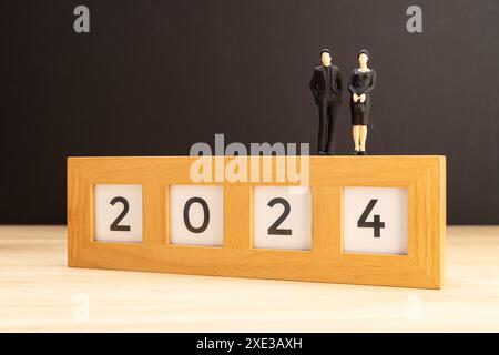 2024 new year concept. Man and woman figurine on top of 2024 sign. Copy space Stock Photo