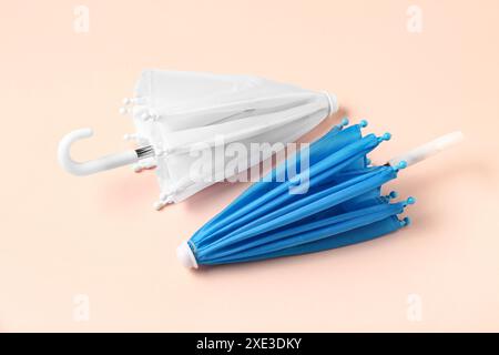Mini stylish umbrellas on beige background Stock Photo