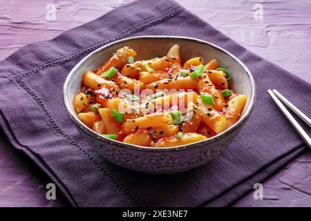 Tteokbokki or topokki, Korean street food, spicy rice cakes in red pepper gochujang sauce, a popular dish in a cafe Stock Photo