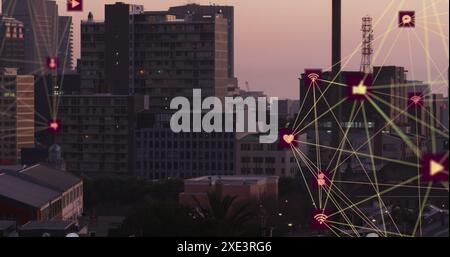 Image of two globes of digital icons spinning against aerial view of cityscape Stock Photo
