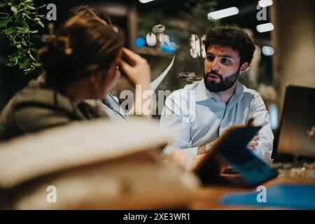 Start up team collaborating on a new project at a casual coffee bar late at night Stock Photo