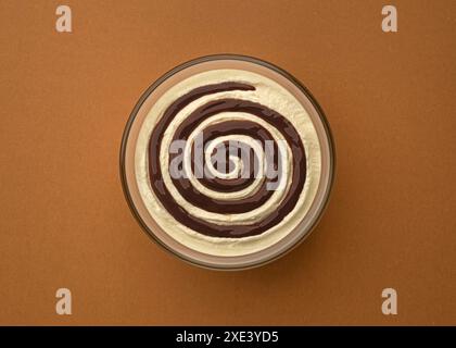 Cream cheese with chocolate cream swirl on brown background, top view Stock Photo