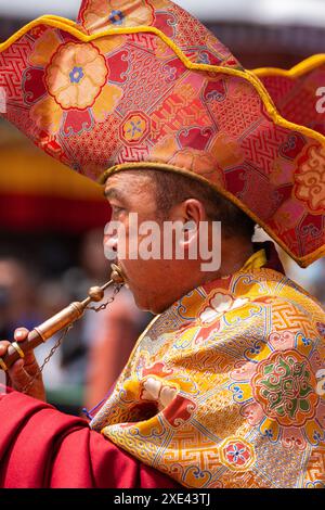 A Ladakhi monk playing a musical instrument wearing traditional costume during Hemis festival at Leh, India on 17 June 2024 Stock Photo