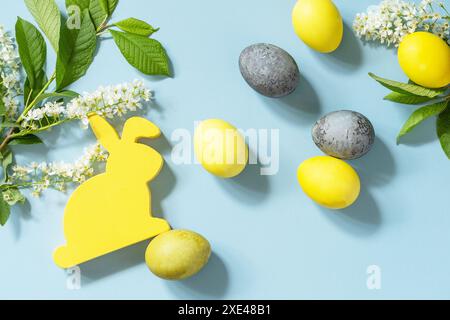 Easter background. Happy Easter concept with rabbit, natural colorful easter eggs and spring flowers on a blue background. Top v Stock Photo