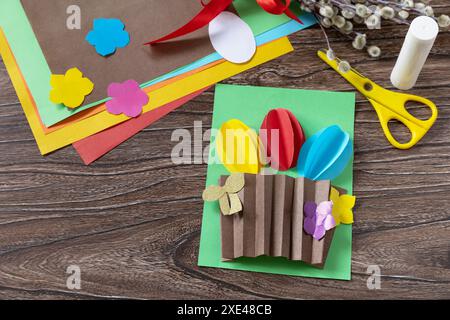 Easter congratulation card with basket easter eggs on wooden table. Handmade. Project of childrens creativity, handicrafts, craf Stock Photo