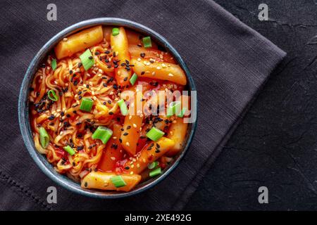 Rabokki, tteokbokki or topokki with ramen, Korean street food, spicy rice cakes in red pepper gochujang sauce, overhead flat lay shot Stock Photo