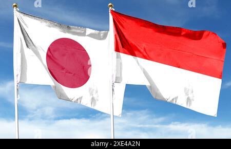 Japan flag and Indonesia flag on cloudy sky. waving in the sky Stock Photo